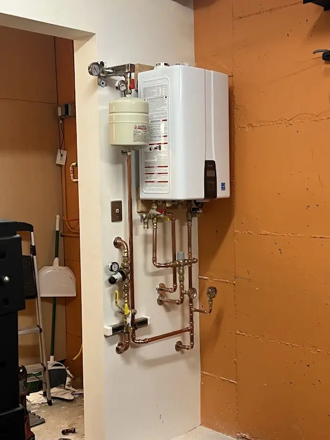 Plumbing technician inspecting water heater connections in Castroville